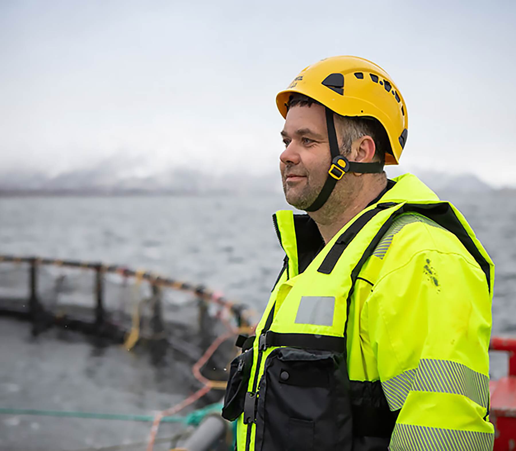 Salmon farmer on the side of the sea pen